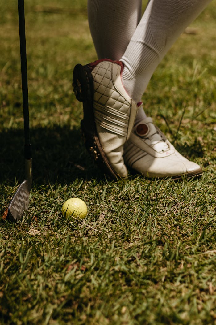 Golf Club and Ball near Shoes of Standing Person